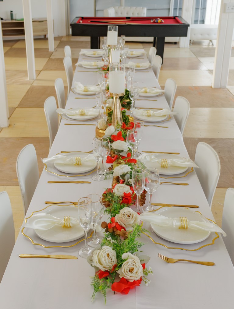 Binge’s indoor venue with a long table dressed in white and gold